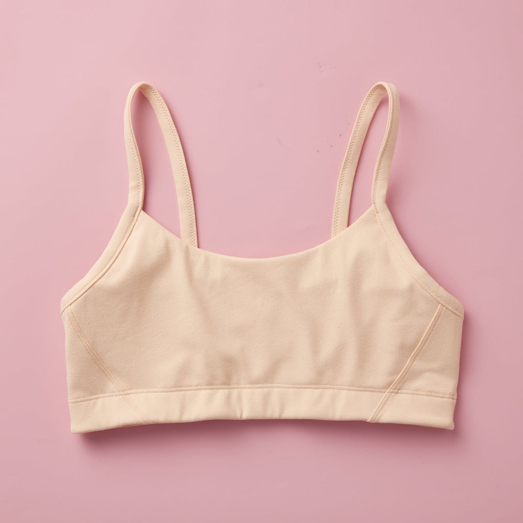 Styled detail image of Yellowberry Sky Bra in beige. The Sky Hybrid Sports Bra is double-layered and fully lined to ensure full coverage and medium to high support. Softest fabrics, AND made by a female founded company.