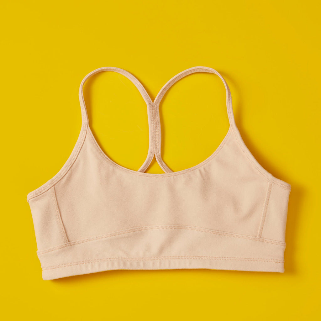 Front close detail image of Yellowberry Tink Hybrid Sports Bra in beige. Like two bras in one! Made with high quality, double-layered, antimicrobial, moisture wicking fabric. 