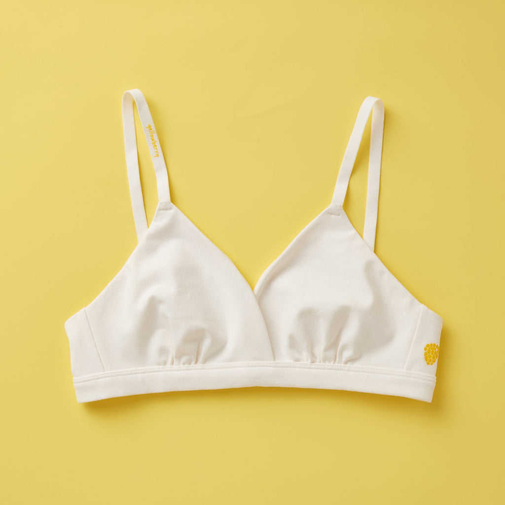 Yellowberry Butter Bra in bright white, front laydown detail image. The BEST Bra We Make for More Developed Girls. Fabric is smooth to the touch and made with a matte brushed finish for extra softness. Made with synthetic fabric blend and hook and eye clasp closure. Great for developing girls. Wear and wash is over and over again, it will still look brand new. It will grow with your daughter as she continues to grow, great option for any occasion.