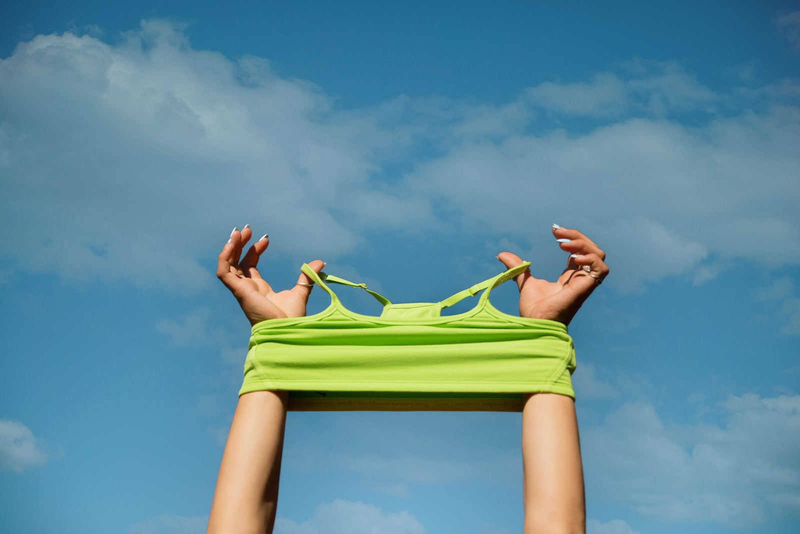 A girl stretching a Yellowberry bra against the blue sky
