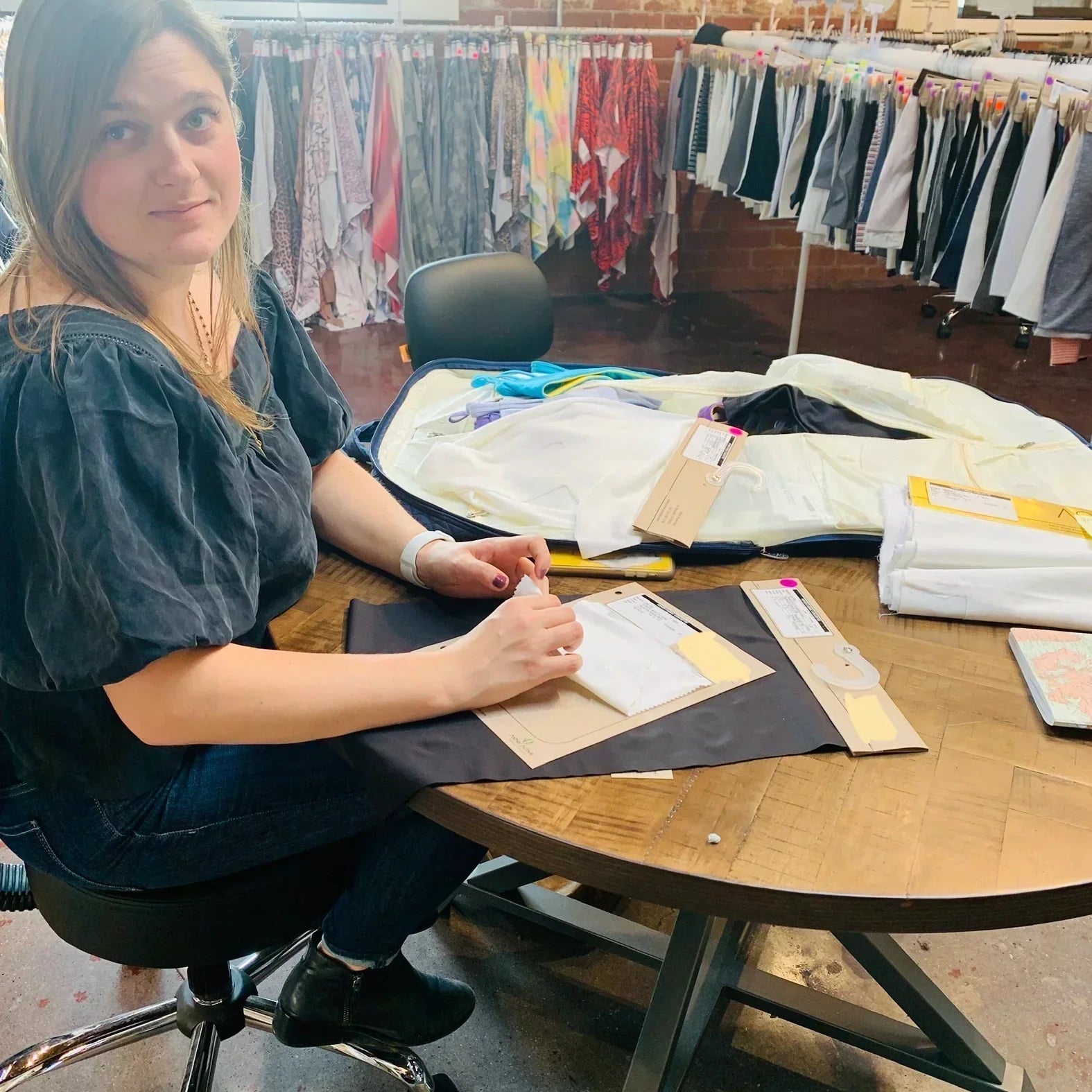 Yelloweberry Founder is going over different fabrics and materials for Yellowberry products in a design studio office.