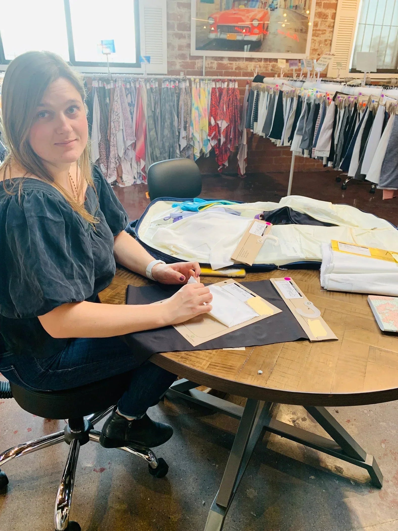 Yelloweberry Founder is going over different fabrics and materials for Yellowberry products in a design studio office.