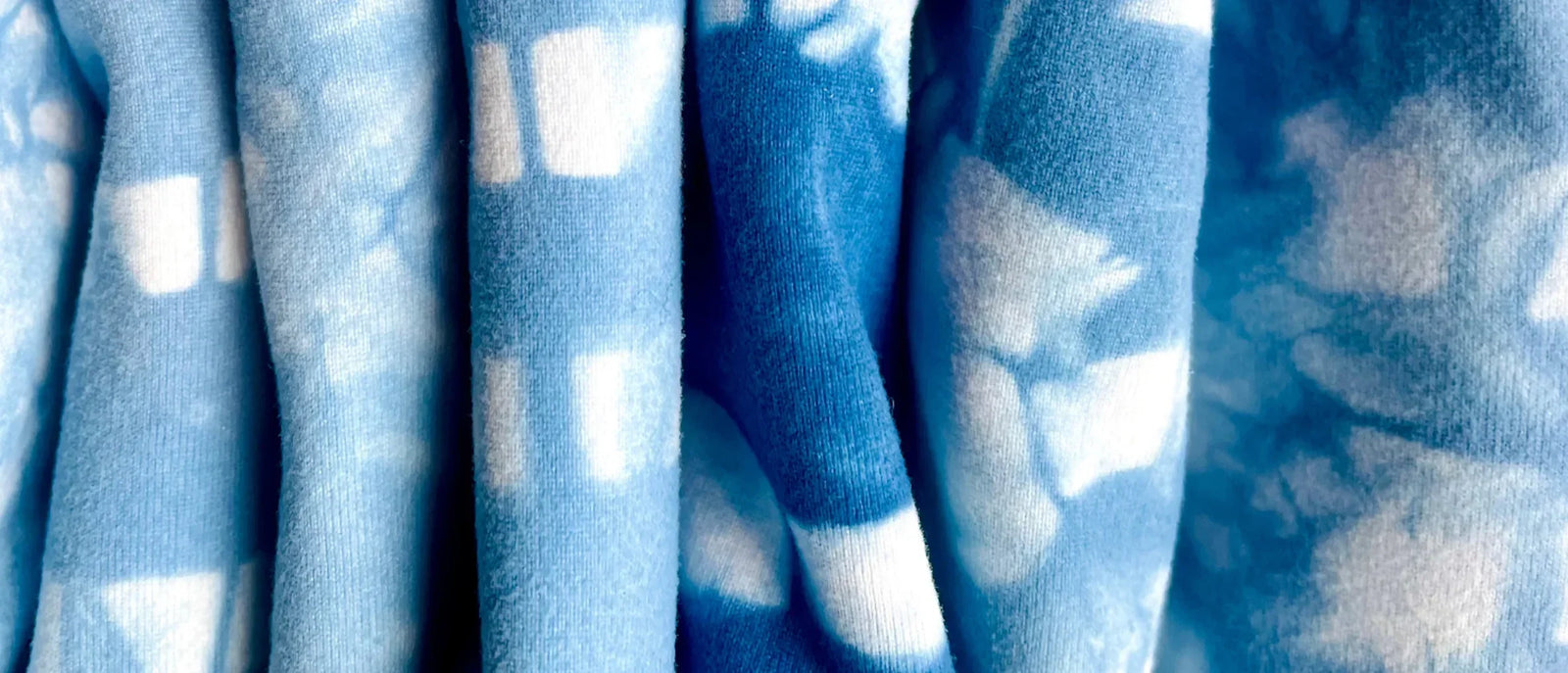 Blue and white Yellowberry garments are folded for a close-up image of the fabric and colors.