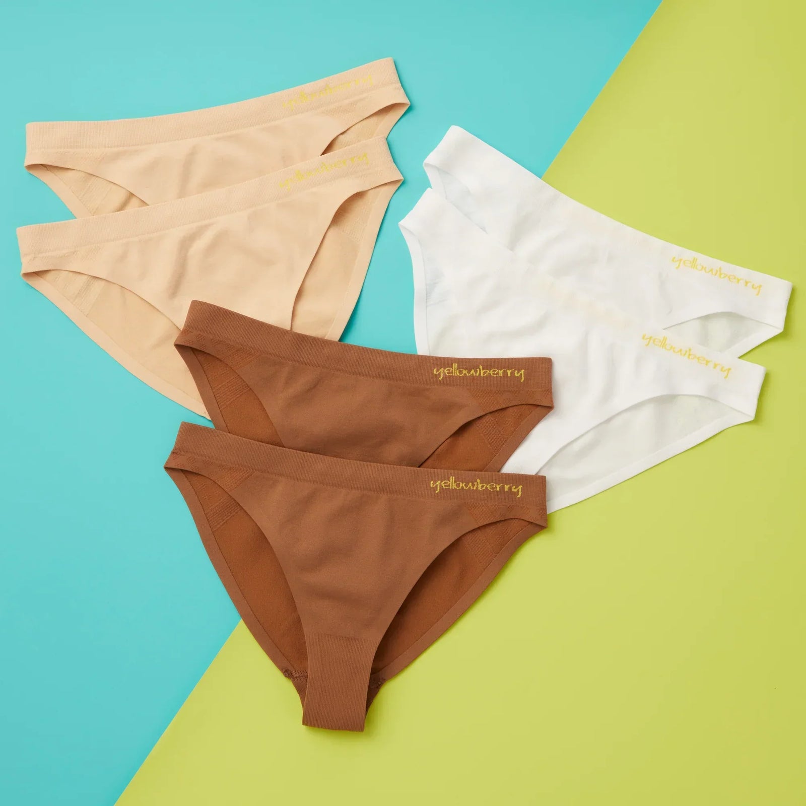 An assortment of Yellowberry Seamless Underwear int he Scout Style - beige, mocha, and white colors all on a multi colored background.