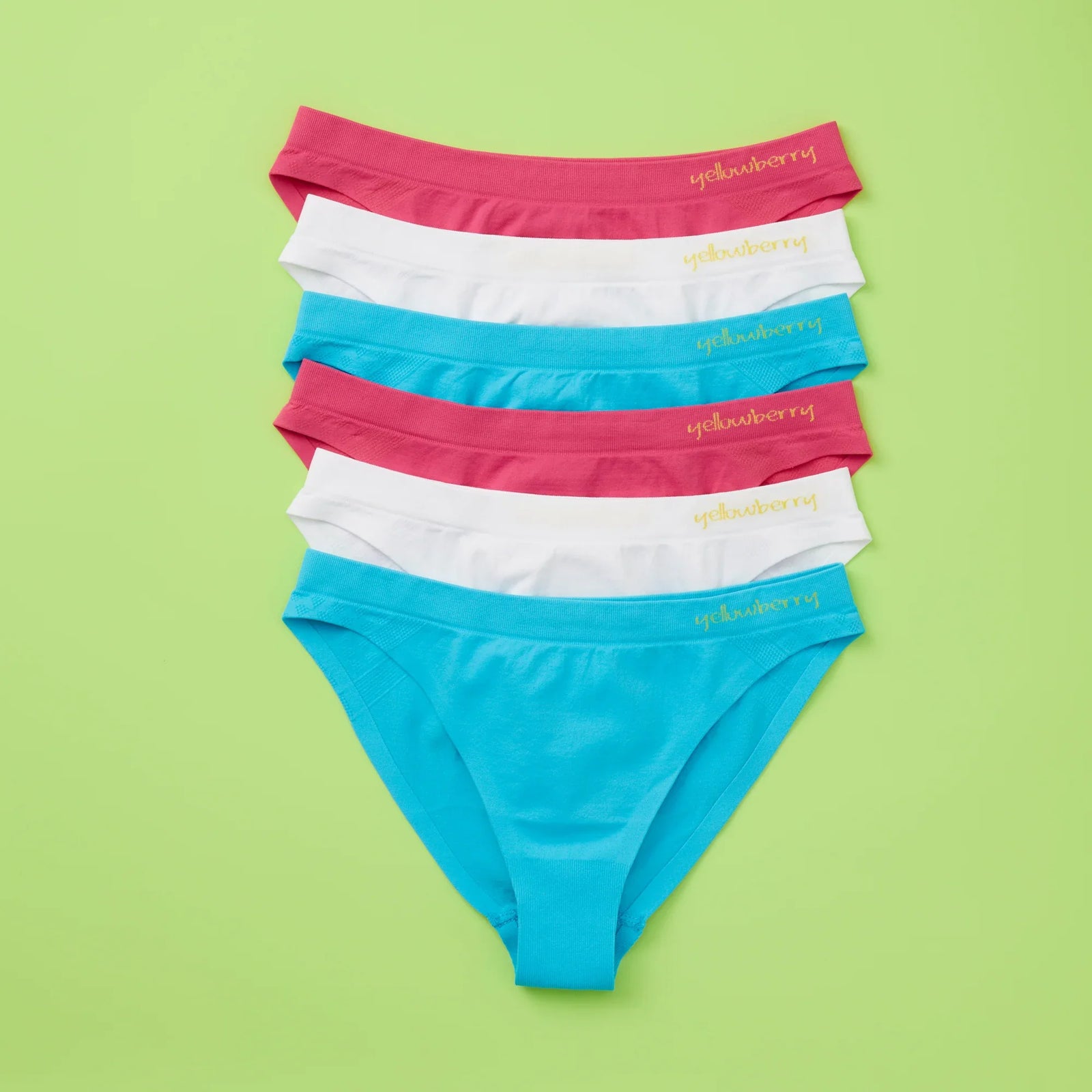 A seamless bundle of Yellowberry Scout Underwear photographed on a light green background. The underear are watermelon pink, fremont blue, and white.