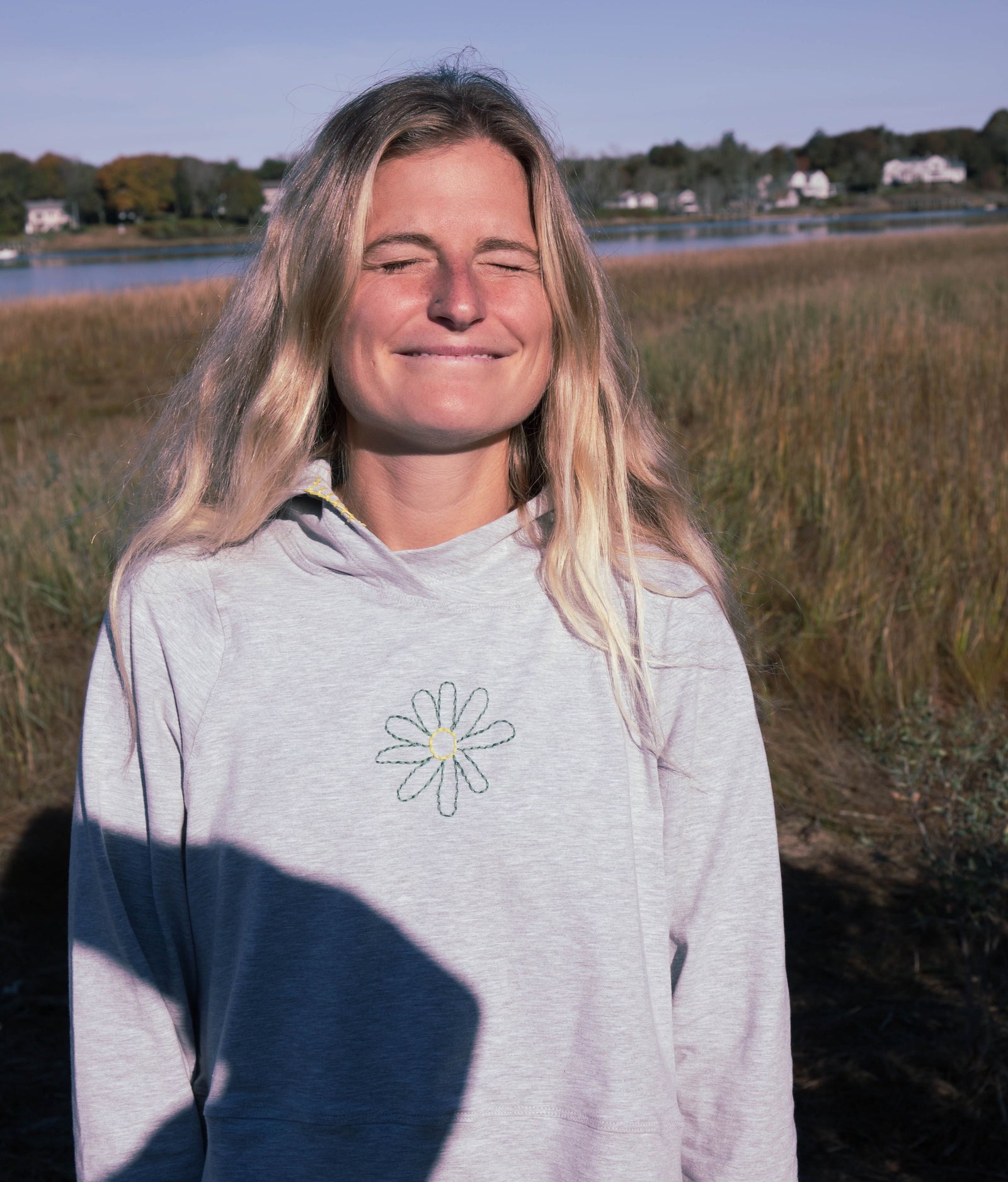 Girl smiling with her eyes closed at the camera, wearing a cotton top
