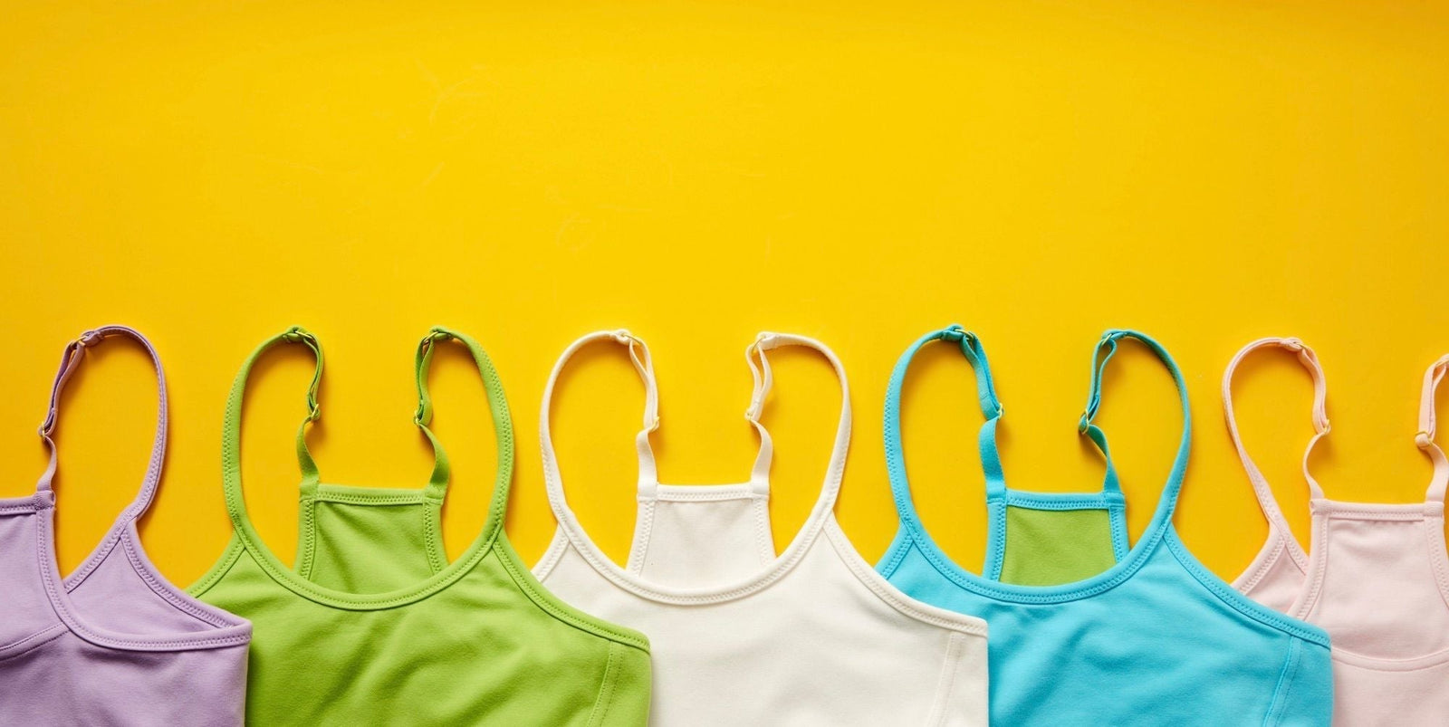 Yellow background with 5 Yellowberry Willow Cotton Bras styled on top. Each one is a different color (purple, green, white, blue, pink) and they are styled at the bottom of the image.