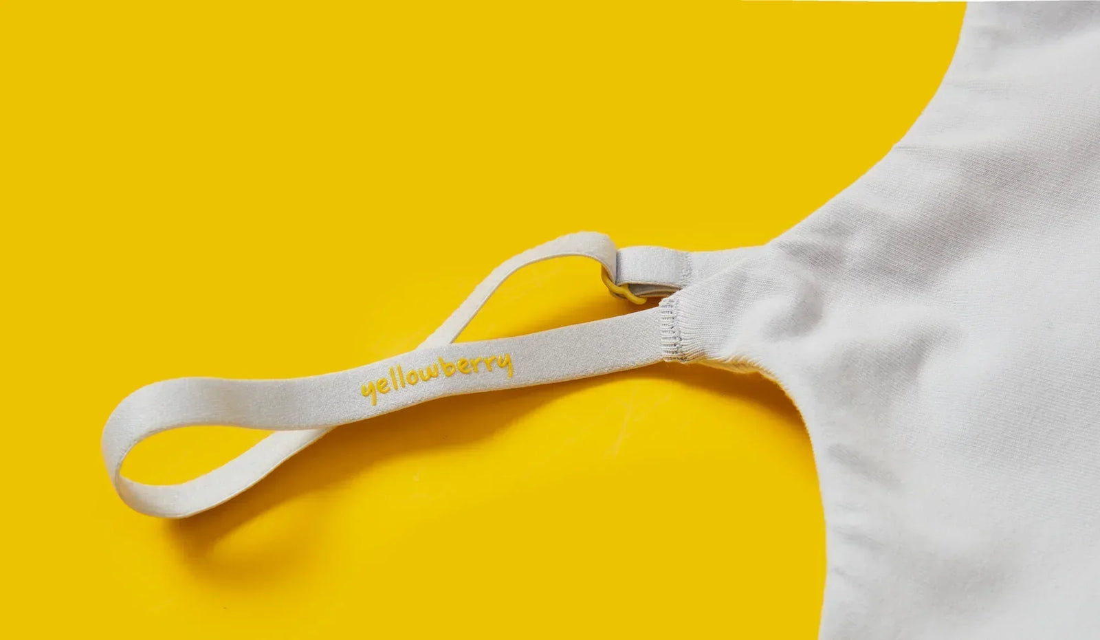 A Yellowberry Bra strap close up on a yellow background
