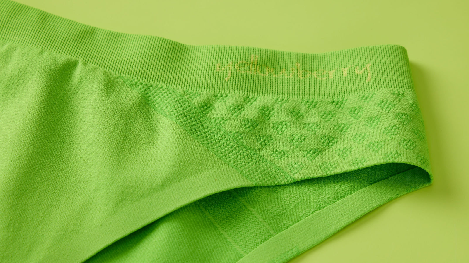 Green pair of Yellowberry seamless underwear on a light green background.