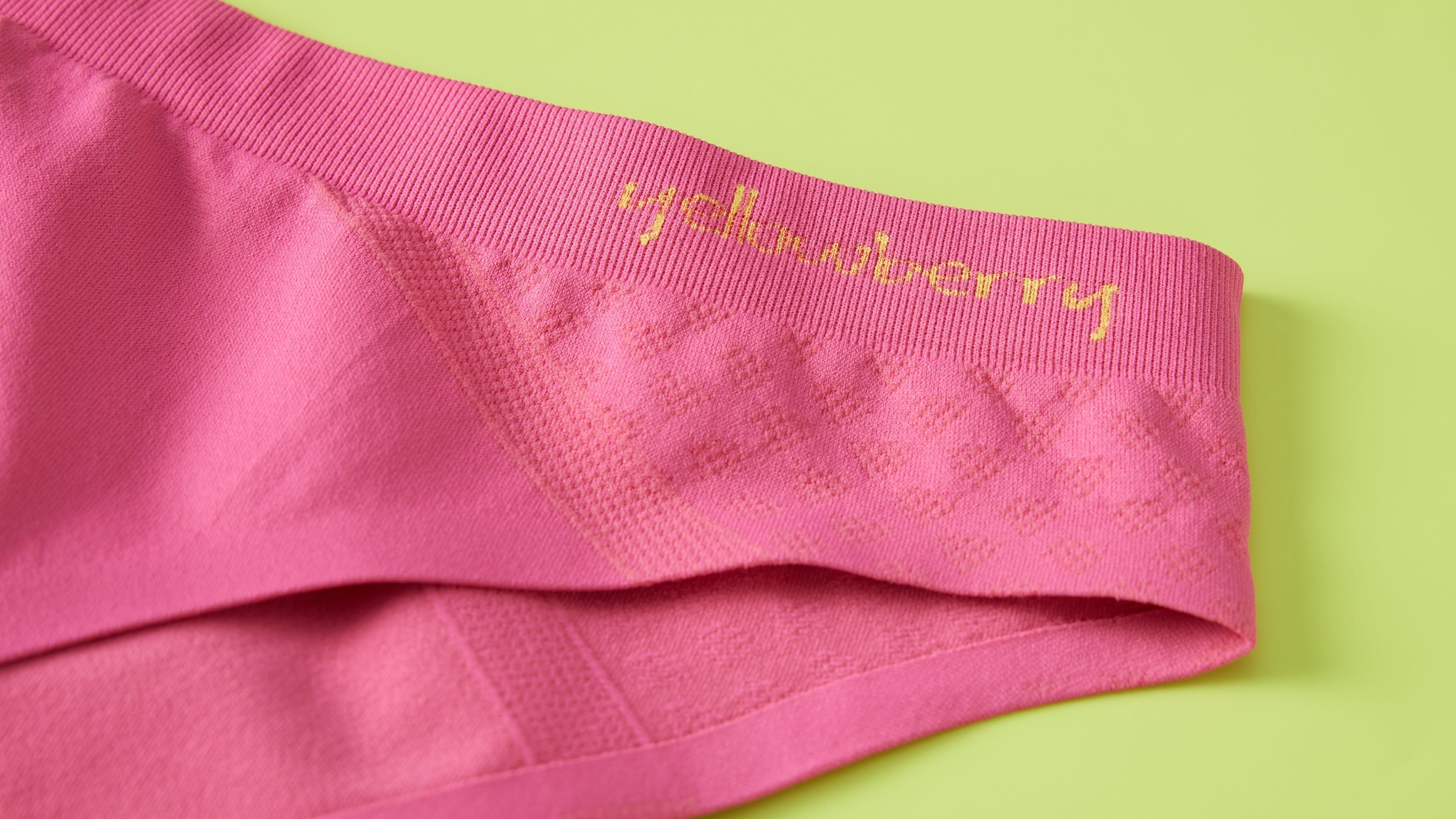 Watermelon pink colored Yellowberry seamless underwear displayed on a green background.