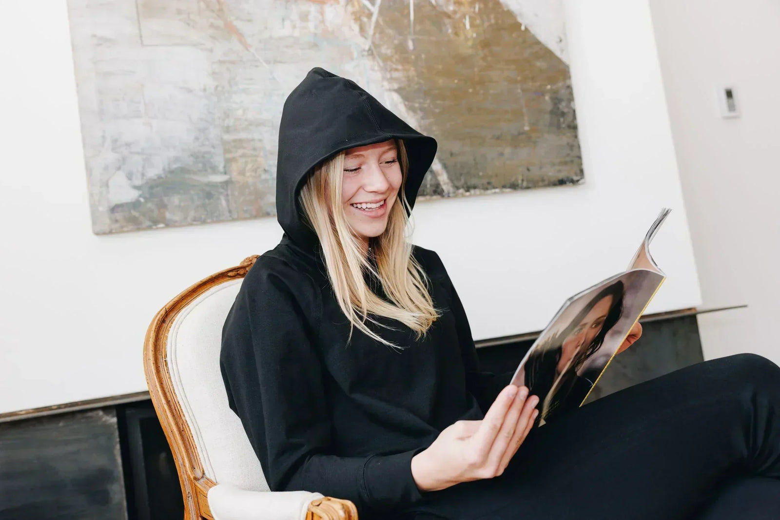 Girl sitting in a chair reading a magazine. She is laughing and wearing a matching set of Yellowberry Loungewear in the color starry night.