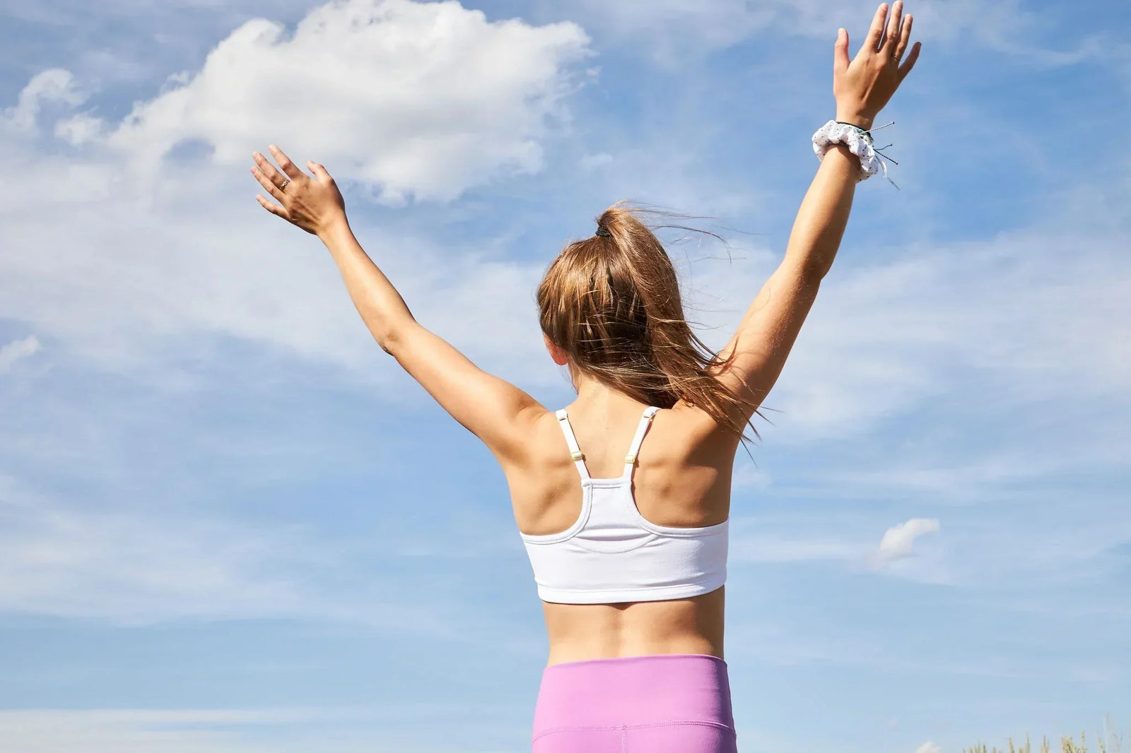 A girl wearing a Yellowberry bra facing a blue sky