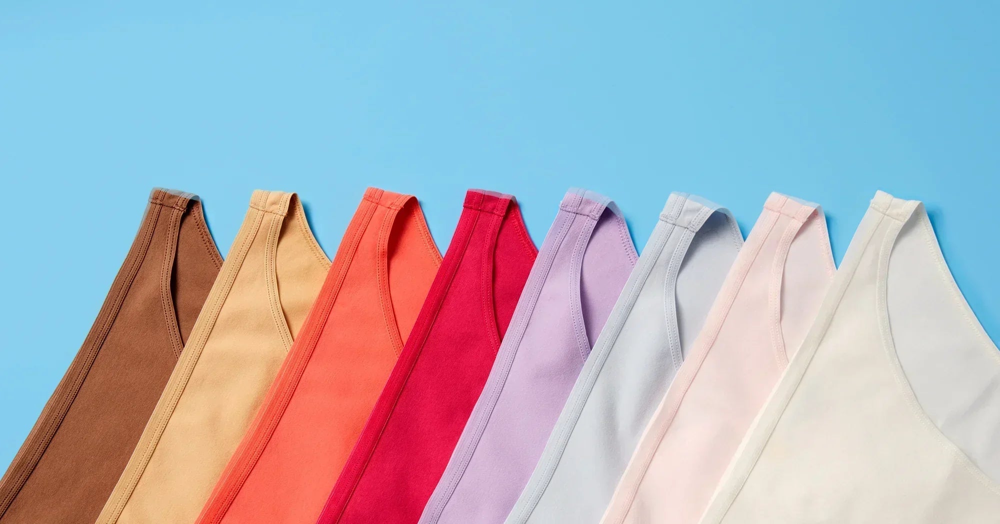 In Raindow color order, an assortment of Yellowberry underwear are styled together on a blue background.