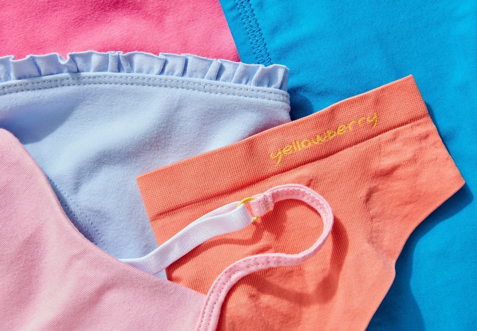 An assortment of brightly colored Yellowberry bras and underwear styled for a detail image.
