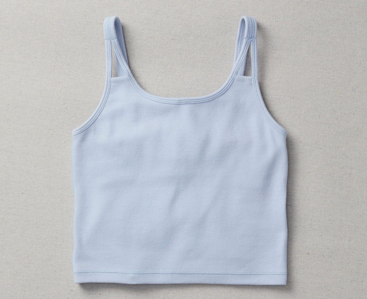 Light blue cotton girls crop top on a linen background