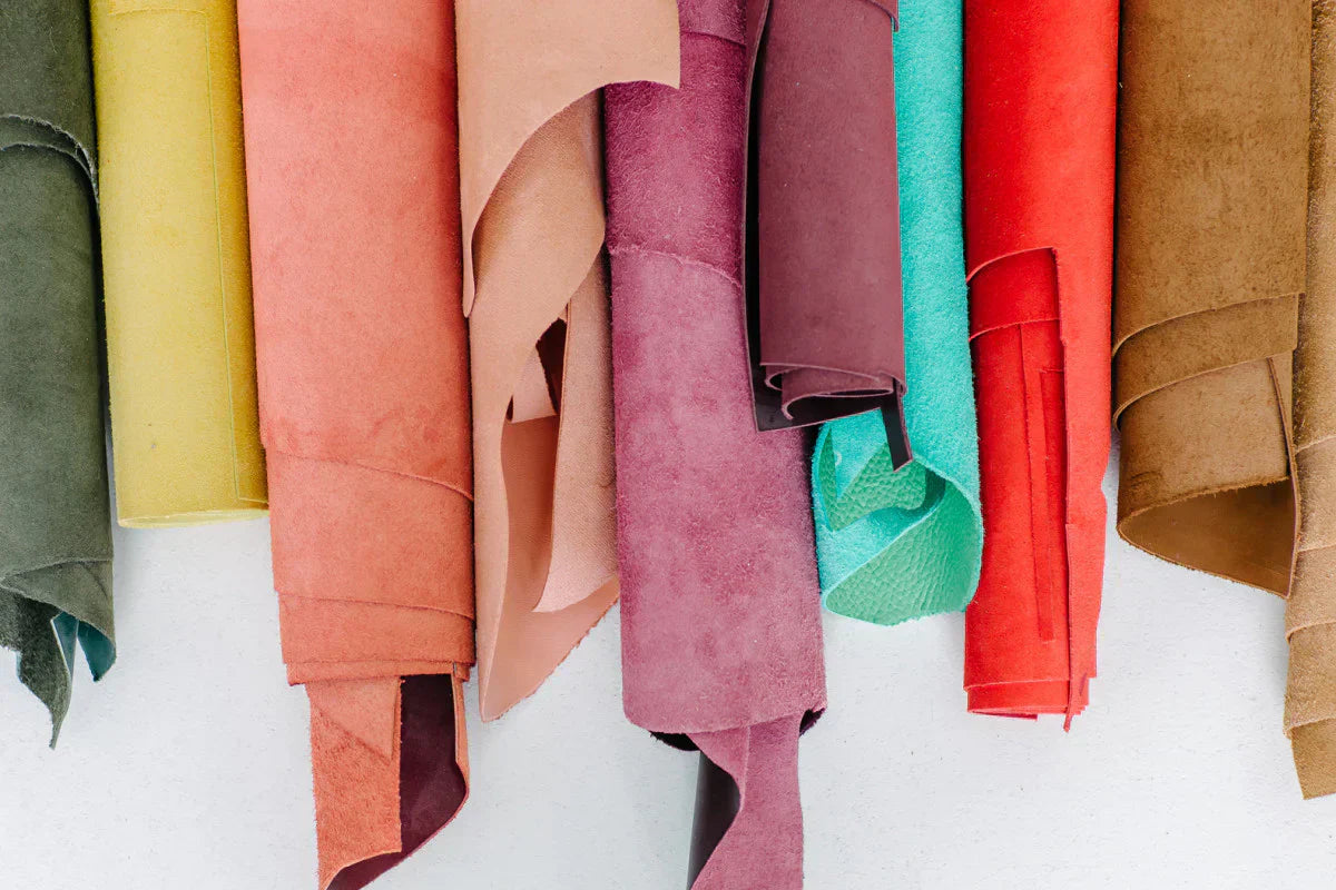 An arrangement of different colors and types of fabric rolls laid next to one another