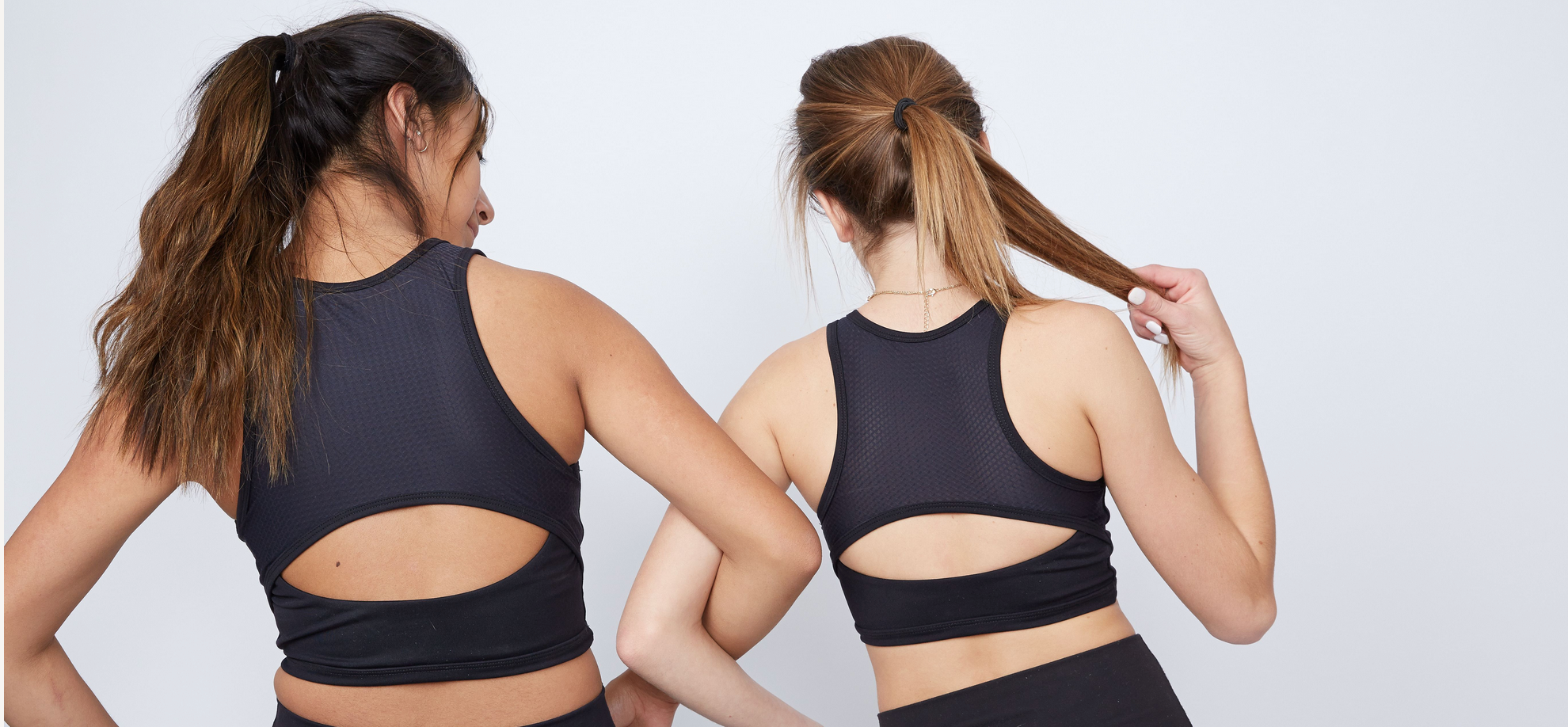 Two girls wearing matching black crop tops by Yellowberry