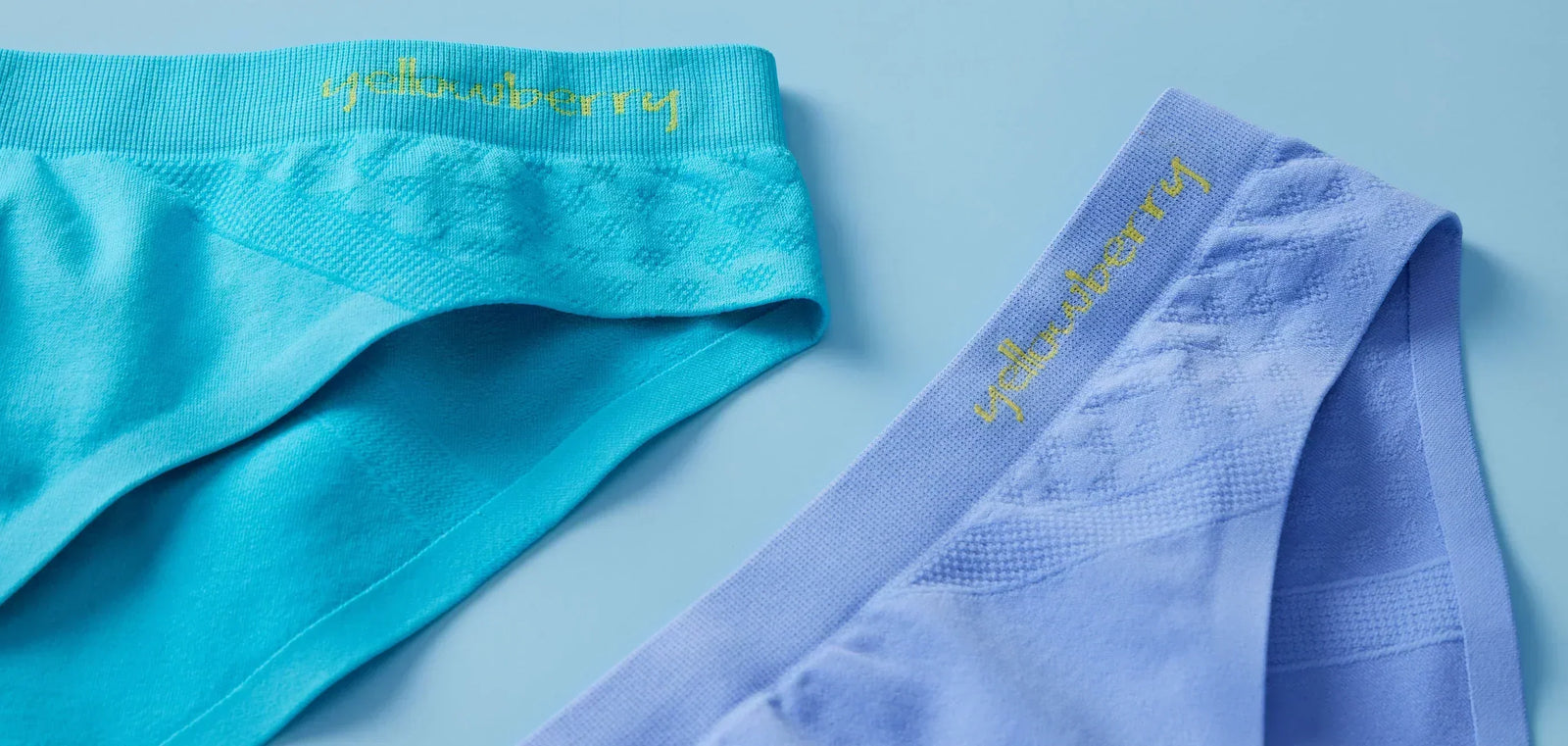 Two pair of Yellowberry Seamless Underwear. One is Ocean blue, the other is Wave blue and they are styled on a soft blue background