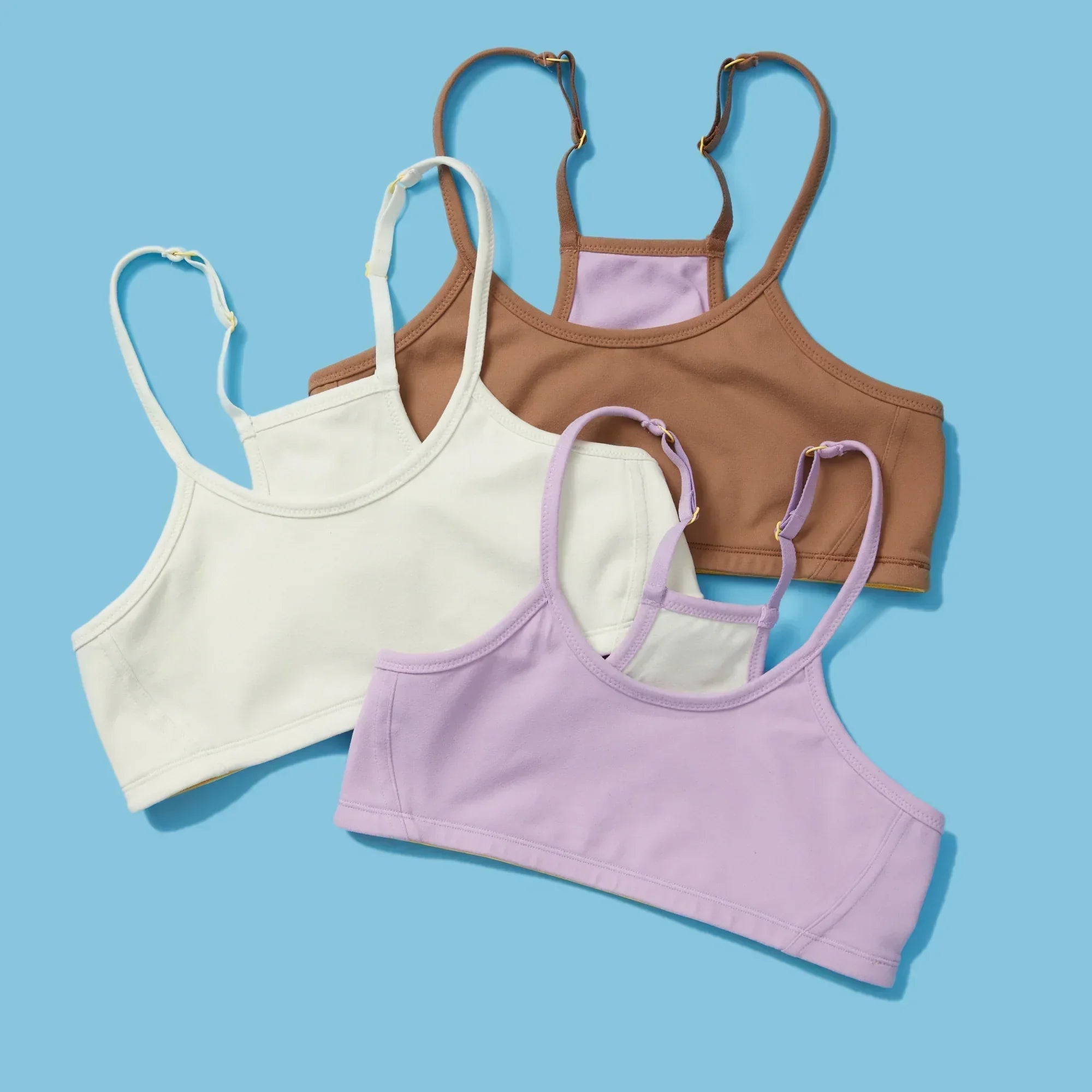 Three Yellowberry Firefly Bras assorted on a blue background
