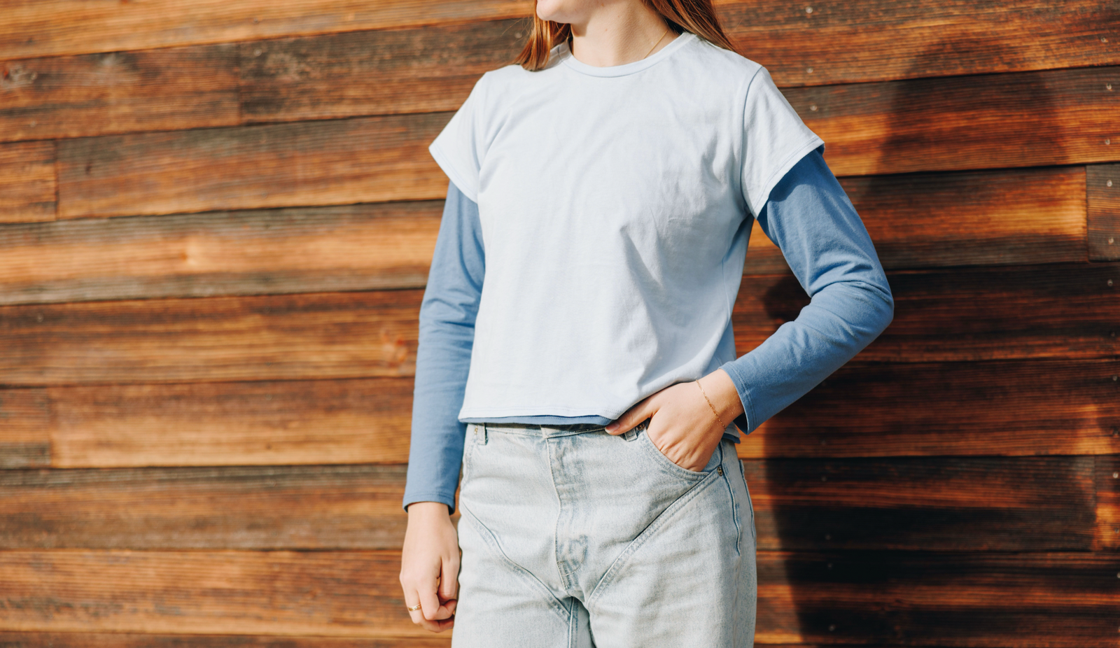 Girl wearing a long sleeve cotton blue t-shirt layered underneath a lighter blue cotton t-shirt