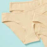 close up image of 6 pair of girls cotton bikini cut underwear on an aqua background, front