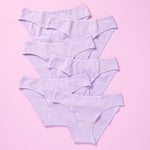 6 pair of light purple girls cotton bikini cut underwear on a pretty pink background, front