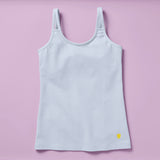 Laydown image of the front of a light blue cotton camisole with a shelf bra on a light purple background
