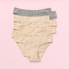 Eight pairs of women's underwear in beige and gray on a pink background