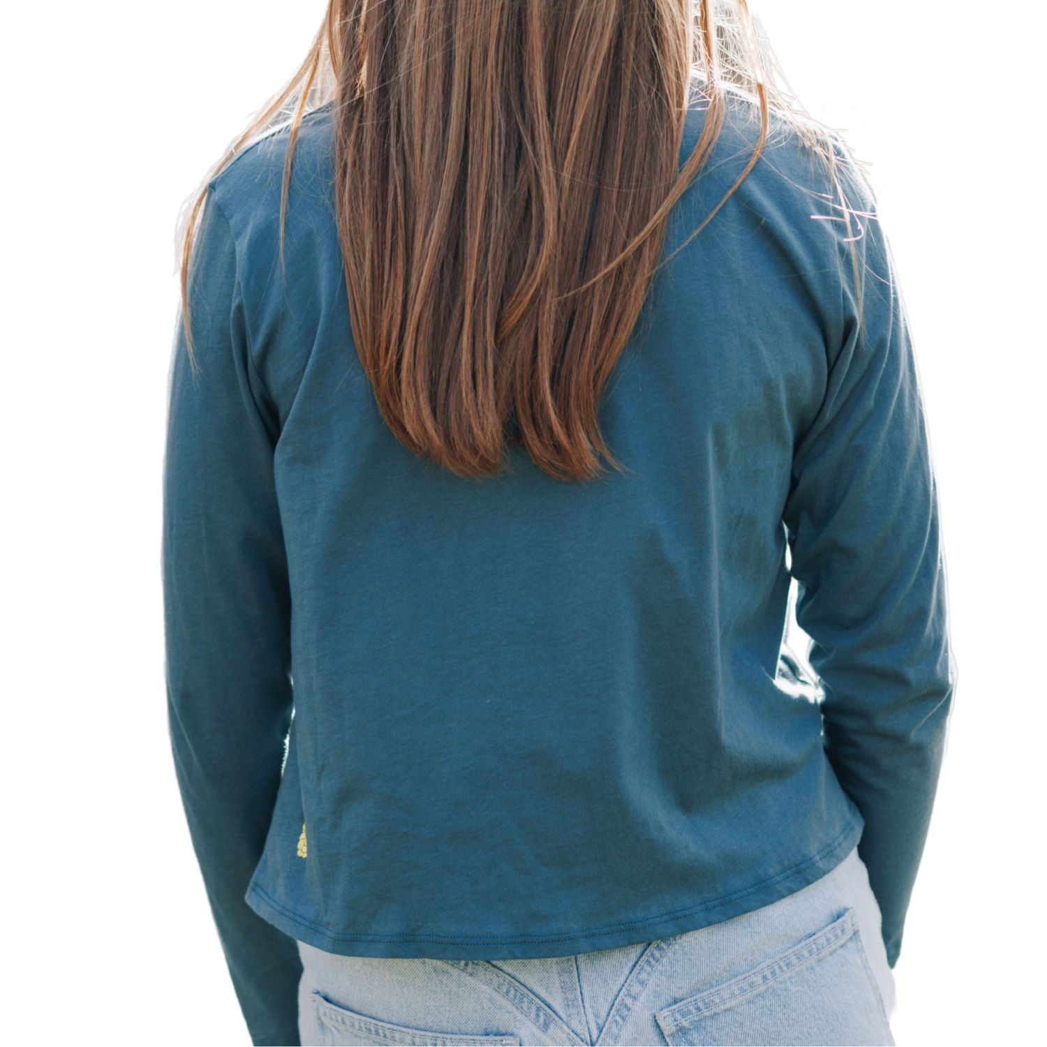 A person wearing a long-sleeved teal t-shirt paired with jeans, viewed from the back.