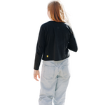 Looking at a girl walking away from the camera, wearing a long sleeve cotton t-shirt by Yellowberry, wearing light washed blue jeans.