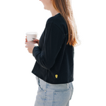 Girl wearing lack long sleeve cotton t-shirt holding her coffee and wearing jeans