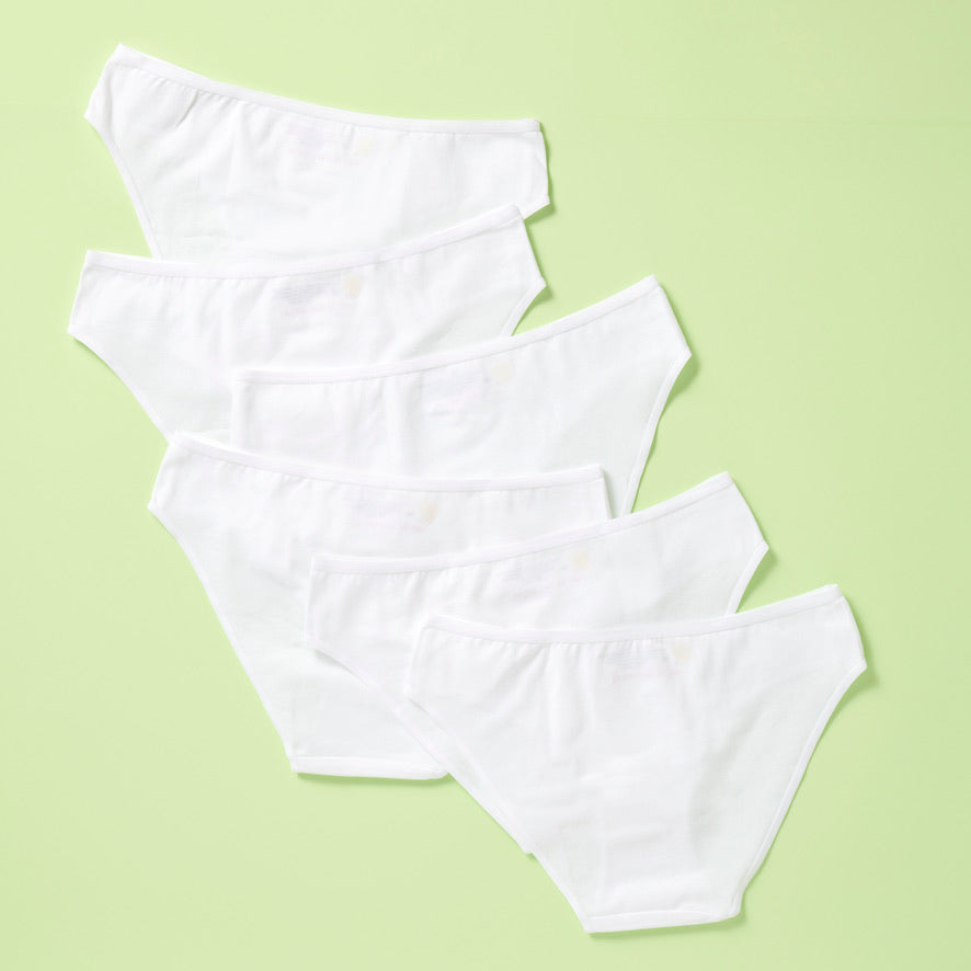 6 pair of cotton bikini underwear assembled on a light green background, back