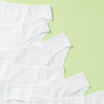 close up of 6 pair of cotton bikini underwear assembled on a light green background