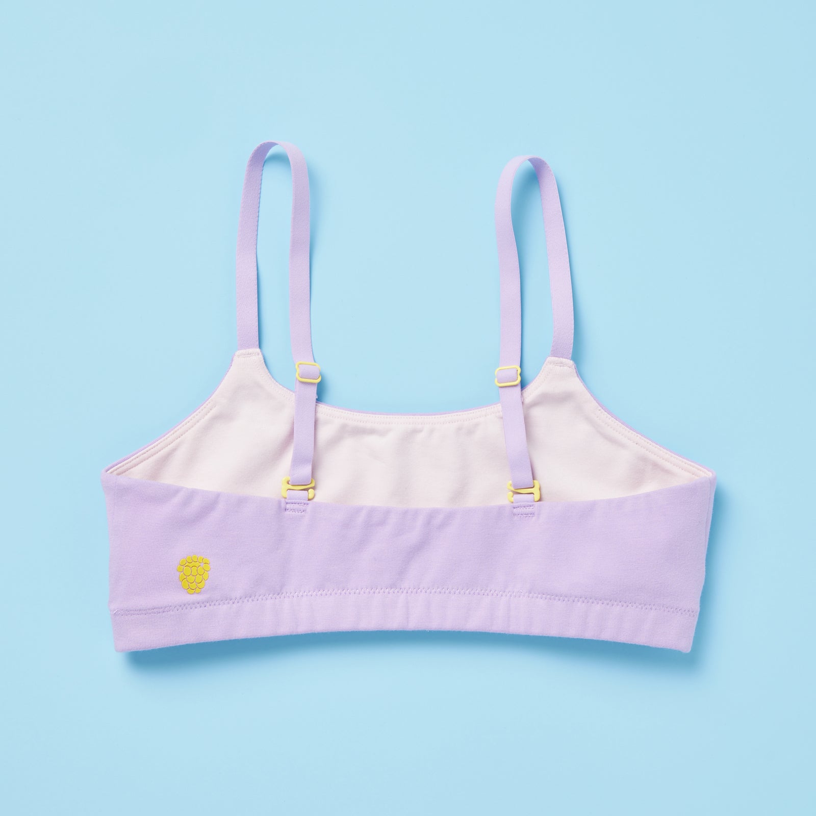 Pipit Huckleberry Cotton Training Bra for gils by Yellowberry lavender bra with white lining and yellow hardware and logo on a blue background