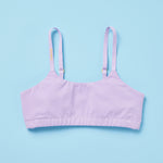 Pipit Huckleberry Cotton Training Bra for gils by Yellowberry with logo written on the strap and is a lavender bra with yellow hardware blue background front image