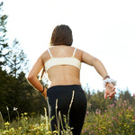 Yellowberry TulipSeamless bra Doe Beige against a mountain of wildflowers in Jackson, Wyoming.