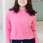 Yellowberry Downtown Hoodie in soft cotton, and effortless Style. Designed with a cross-front hood for subtle flair, it falls just below the navel, hitting the hip for a relaxed, effortless fit. Each piece in our lounge collection embodies chic, timeless style, all essentials you'll reach for all cozy season long. Made with pride in the USA, in colors thoughtfully chosen to mix and match seamlessly. We hope you enjoy them as much as we loved creating them for you. Hot Pink detail front