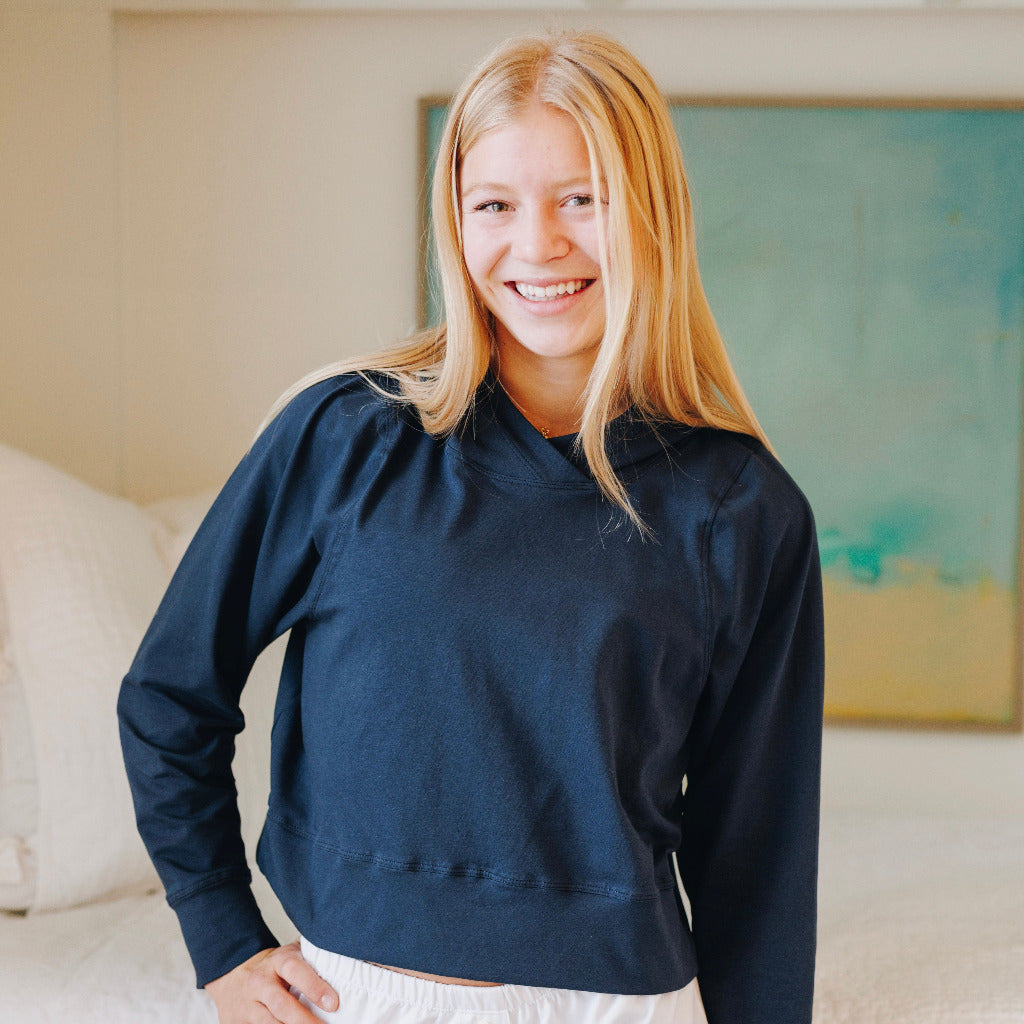 Yellowberry Downtown Hoodie in soft cotton, and effortless Style. Designed with a cross-front hood for subtle flair, it falls just below the navel, hitting the hip for a relaxed, effortless fit. Each piece in our lounge collection embodies chic, timeless style, all essentials you'll reach for all cozy season long. Made with pride in the USA, in colors thoughtfully chosen to mix and match seamlessly. We hope you enjoy them as much as we loved creating them for you. Moonbeam Navy front on model 