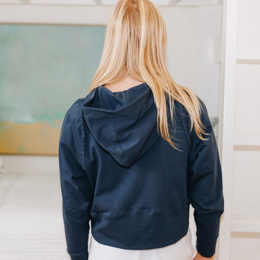Yellowberry Downtown Hoodie in soft cotton, and effortless Style. Designed with a cross-front hood for subtle flair, it falls just below the navel, hitting the hip for a relaxed, effortless fit. Each piece in our lounge collection embodies chic, timeless style, all essentials you'll reach for all cozy season long. Made with pride in the USA, in colors thoughtfully chosen to mix and match seamlessly. We hope you enjoy them as much as we loved creating them for you. Moonbeam Navy back casual detail