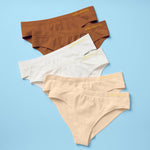 Best-Selling Twistr Girls Seamless Bikini cut underwear by Yellowberry. Front image of sunset (white, beige, mocha colors) bundle on blue background. 