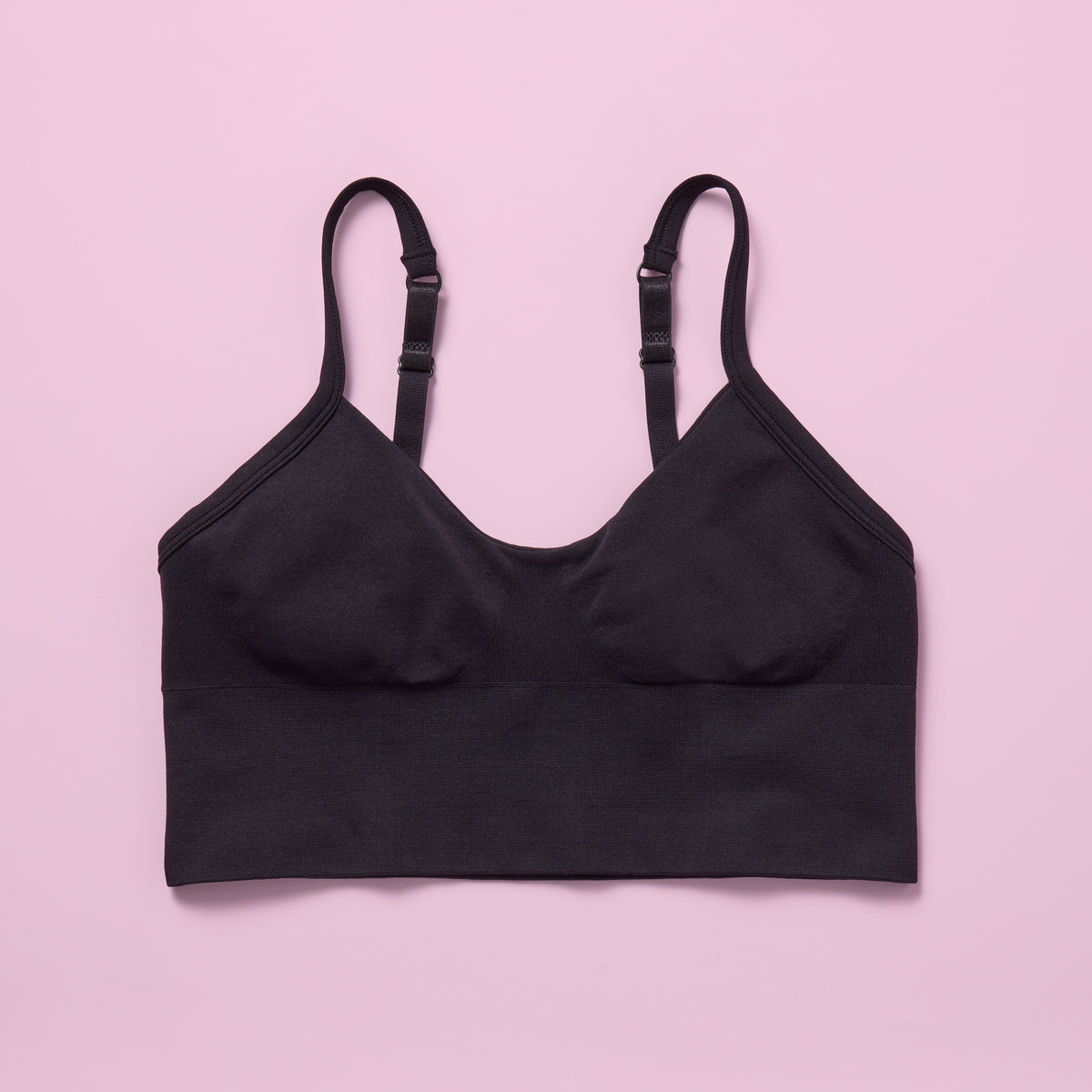 Black seamless crop bra on a pink background