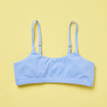 Yellowberry Pipit Training Bra for girls in Ocean (light blue) on a light yellow background, front of the bra