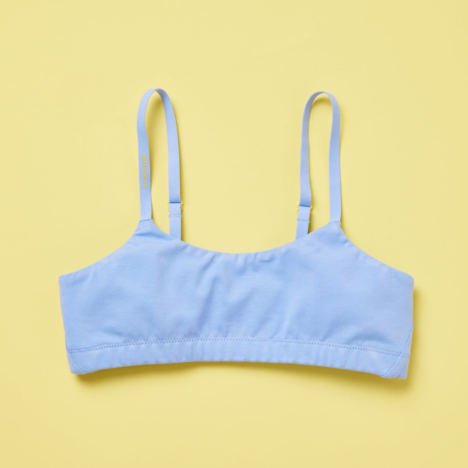 Yellowberry Pipit Training Bra for girls in Ocean (light blue) on a light yellow background, front of the bra