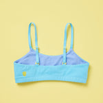 Yellowberry Pipit Training Bra for girls in Wave (aqua blue) on a light yellow background, back. The Yellow Berry logo in on the back left, and the inner color of a different shade of blue adds a fun touch to this quality cotton bra for girls