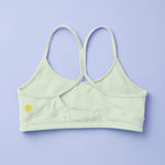Yellowberry Classic Tink Sports Bra in a soft brushed Nylon blend. Pullover design and full support keep it in our Yellowberry best-selling bra category. Beach Glass colorway is also a customer favorite. Light enough to make it a neutral and different enough to make it less common. Back image of Tink Beach Glass on lavender background.