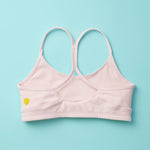 Tink Sports Bra by Yellowberry in a soft brushed nylon blend in a customer favorite color, Bubblegum Pink. Classic pullover design with full support ensures a all-day ease and comfort. Bubblegum is a great new neutral with a sugar twist. Lay down image of Back Tink Bubblegum against a turquoise background.