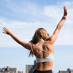 Yellowberry Classic Tink Sports Bra in our newest Storm color. A beautiful new neutral with a hint of a city vibe. Beautiful on all skin tones and a great top drawer addition for all girls. Girl on rooftop in NYC celebrating strong female empowerment for a women-owned brand.