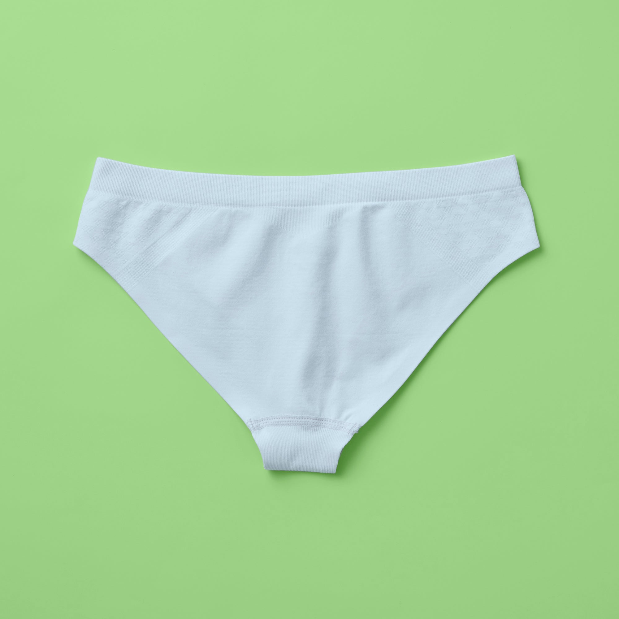 Yellowberry Twistr Seamless Underwear in Raindrop (light blue color) on a green background, back image. These underwear are true seamless, high quality girls underwear and made with super soft fabrics. Girl and mom approved!