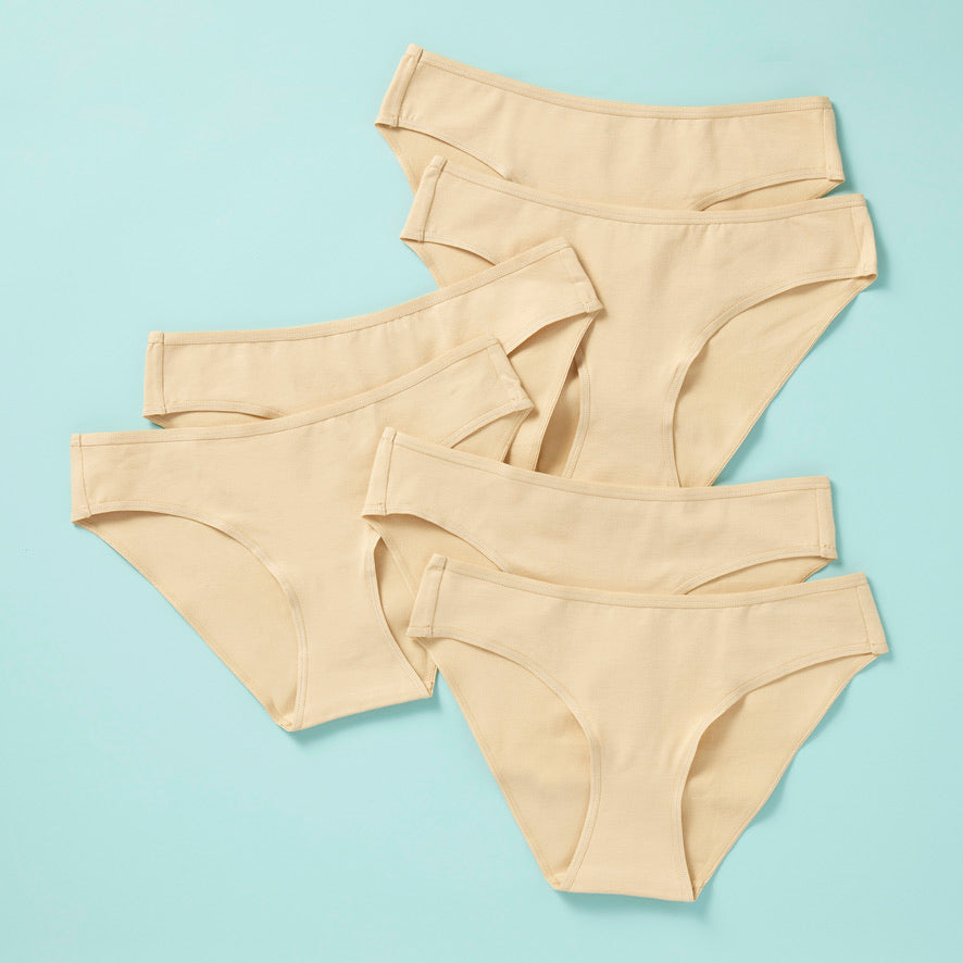 6 pair of girls cotton bikini cut underwear on an aqua background, front