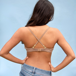 Woman wearing a brown bikini top against a light blue background